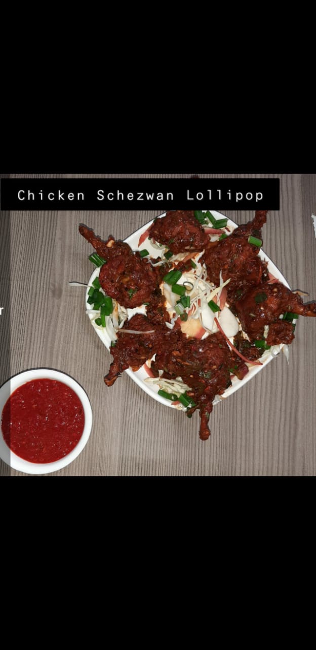 Chicken schezwan lollipop plated with red chilli dip