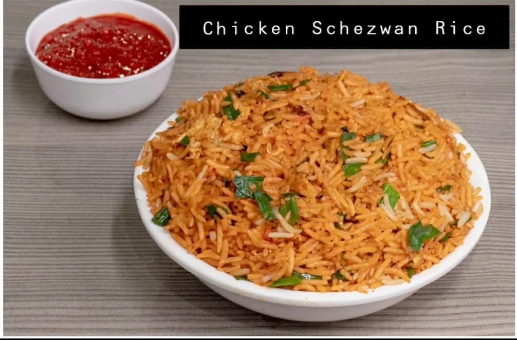 Bowl of chicken schezwan rice with spring onion