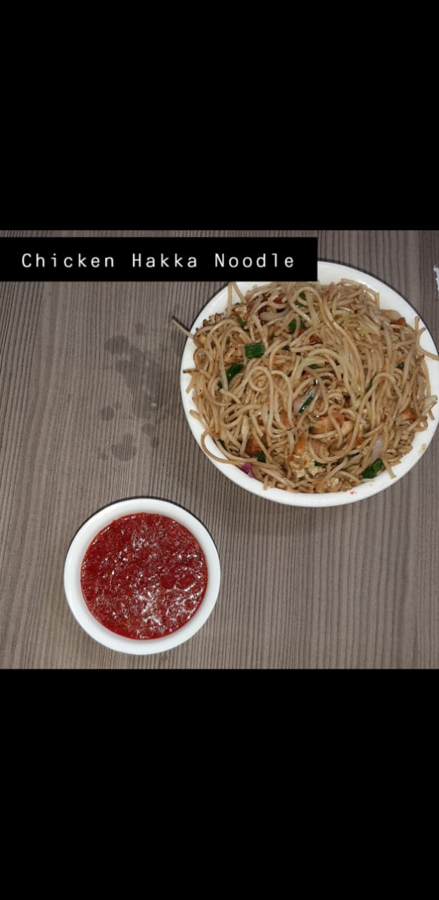 Bowl of chicken hakka noodles with chilli sauce